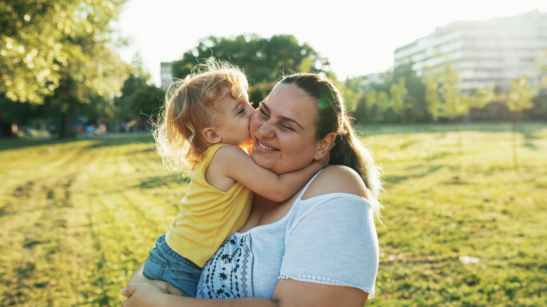 Mother and child hugging in park