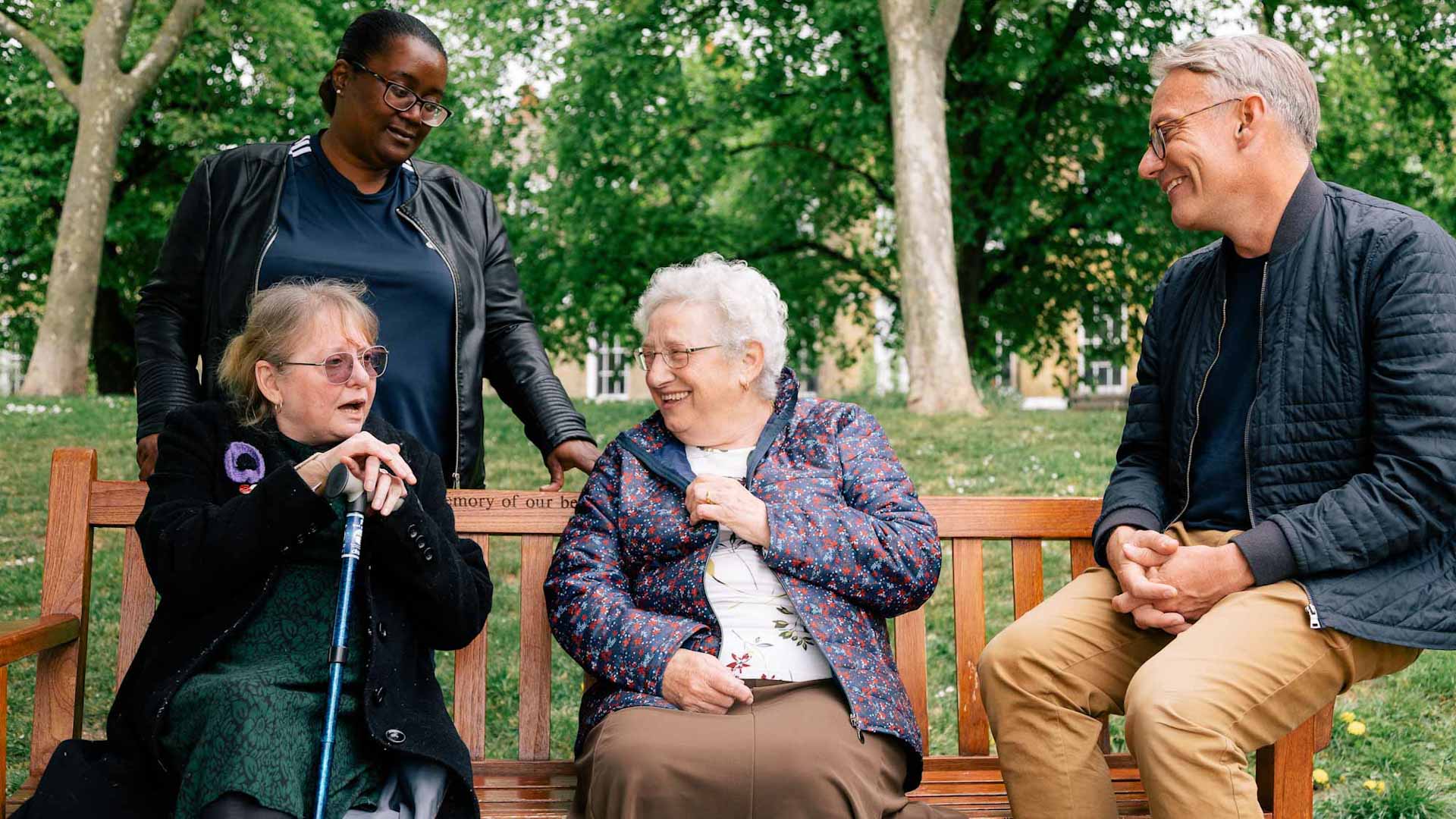 Corin smiling and talking to a group of people